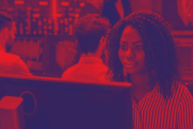 A woman looking concerned at a computer monitor