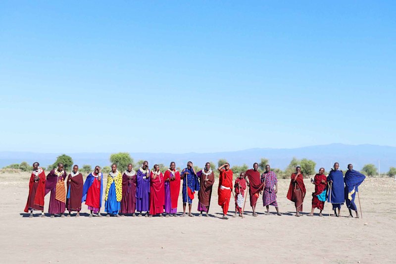 Maasai tribe standing in a line on the sand