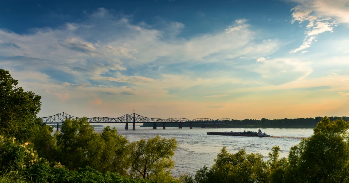 Boat on Mississippi River at sunset | Swyft Filings