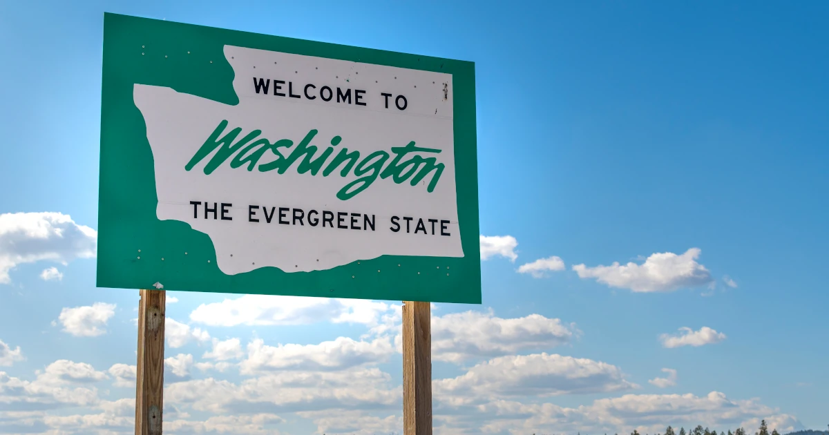 A roadside sign with welcome to Washington State the evergreen state written on it
