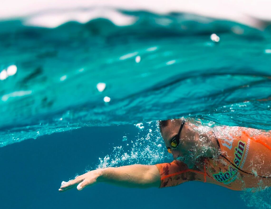 man swimming underwater in ocean