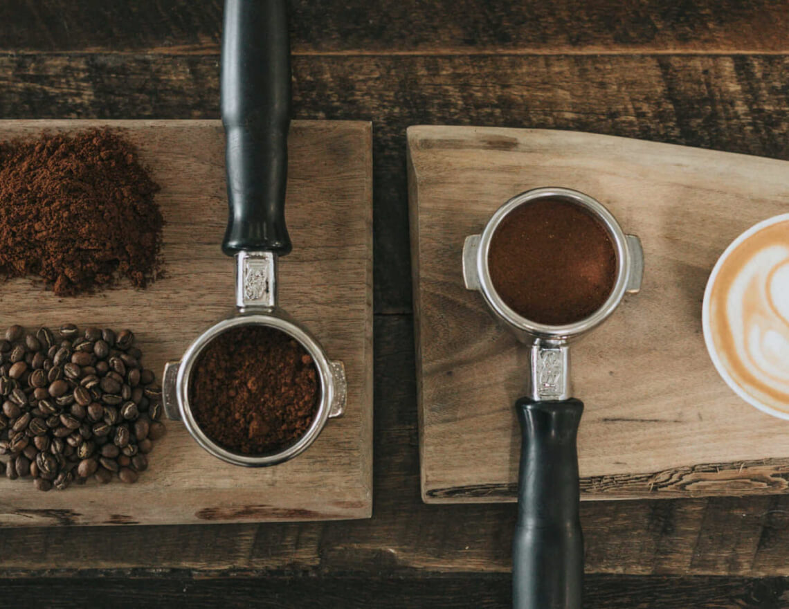coffee cup and coffee beans on wood cutting board