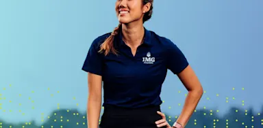 A smiling female golfer at IMG Academy standing on a course, representing positive self-talk and mental confidence in sports.