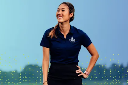 A smiling female golfer at IMG Academy standing on a course, representing positive self-talk and mental confidence in sports.