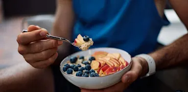 Athlete eating a nutritious bowl of mixed whole foods.
