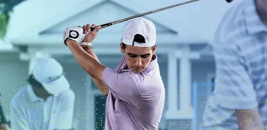 IMG Academy golf athlete mid-swing during practice, wearing a light-colored polo and white cap, with focused posture and club raised at the top of the backswing.