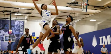 IMG Academy basketball player making a dynamic layup during a game, capturing a key moment often featured in highlight videos.