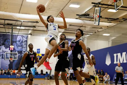 IMG Academy basketball player making a dynamic layup during a game, capturing a key moment often featured in highlight videos.