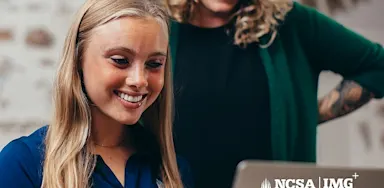 IMG Academy student working on a laptop with guidance from an NCSA College Recruiting advisor, reviewing college recruiting and academic planning resources.