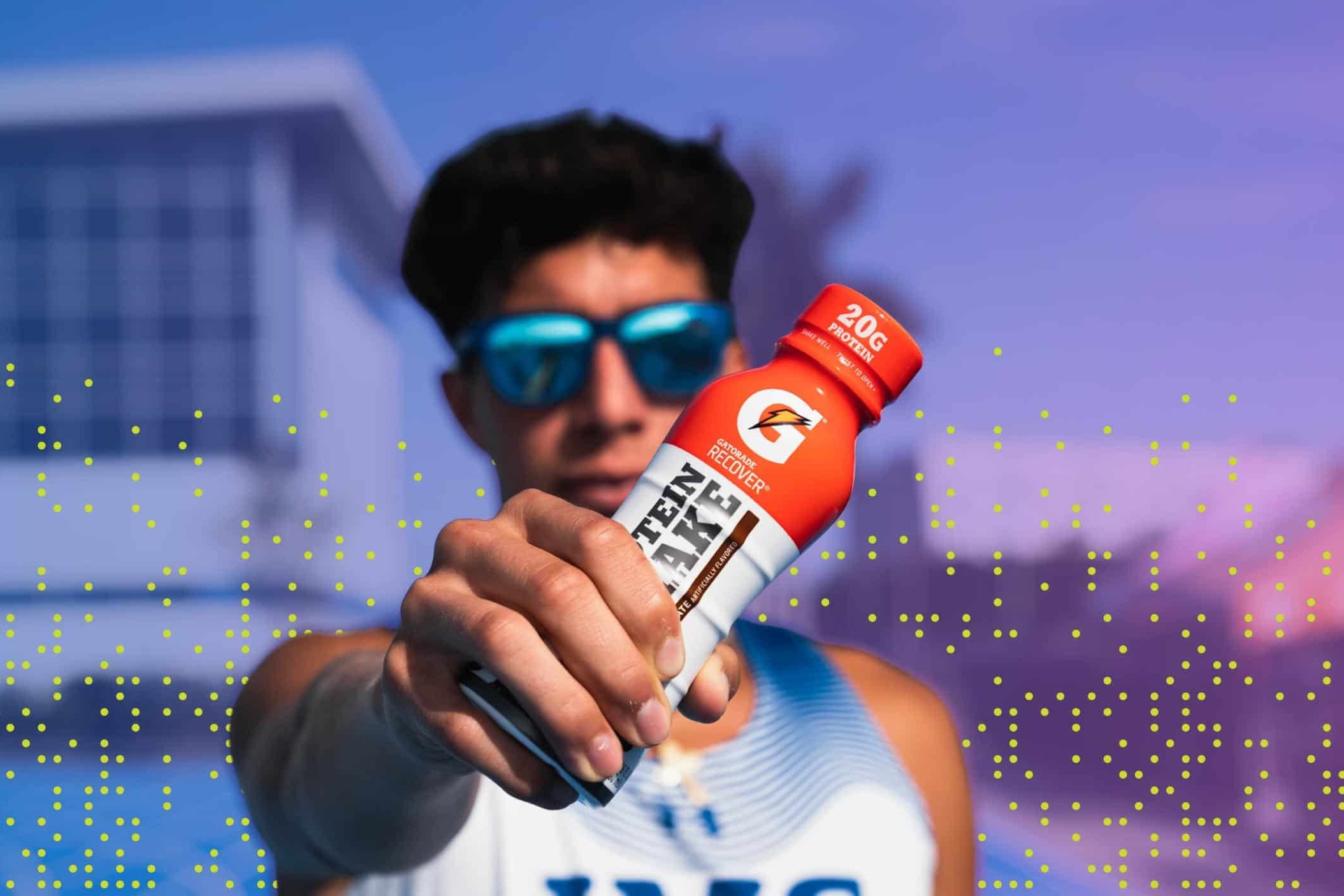 Student athlete holds Gatorade bottle straight ahead and in focus of camera.