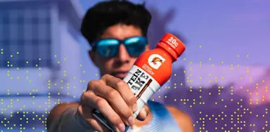 Student athlete holds Gatorade bottle straight ahead and in focus of camera.