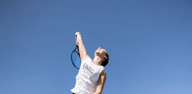 IMG Academy student-athlete serves a tennis ball