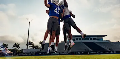 Three IMG Academy football players celebrate a touchdown.