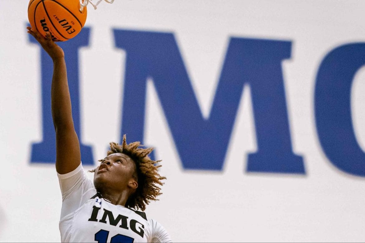 Basketball player reaching for a dunk during a game at IMG Academy.