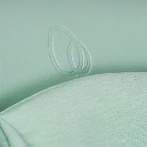 Close-up of the pistachio green vegan leather seat with a tonal embossed Puggle logo and soft jersey liner.