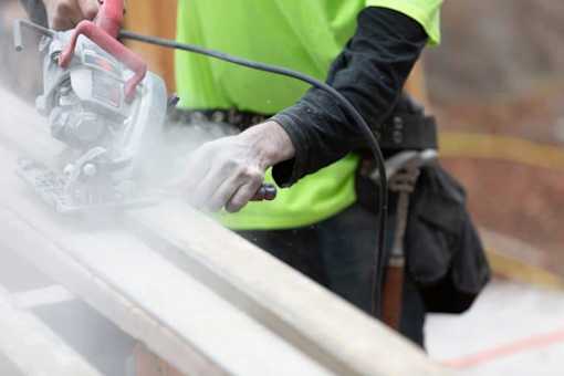 Worker cutting masonite siding