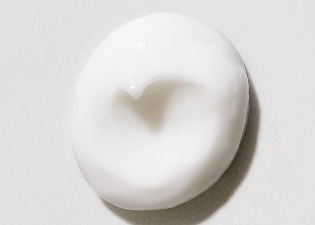 Swirl of hair mask dispensed on a white background.