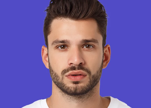A man with medium length brown hair and a beard looks forward in front of a blue background.