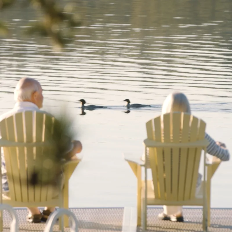 A couple sit in lounge chairs on the dock