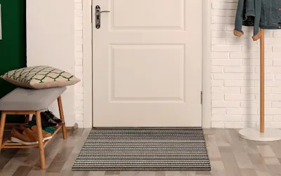 Image d’une entrée de vestiaire avec un tapis devant la porte.
