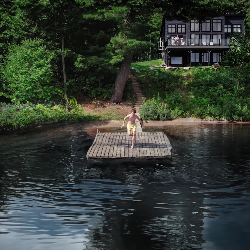 Someone jumps off a dock on the lake