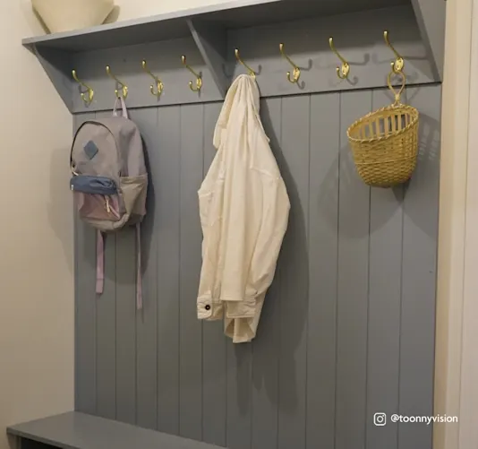 Image of mudroom with several hooks with hanging bag and jacket.