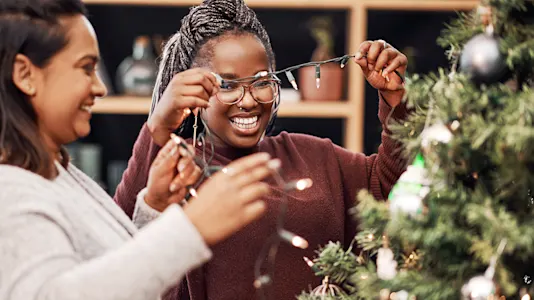 Two people stringing Christmas lights
