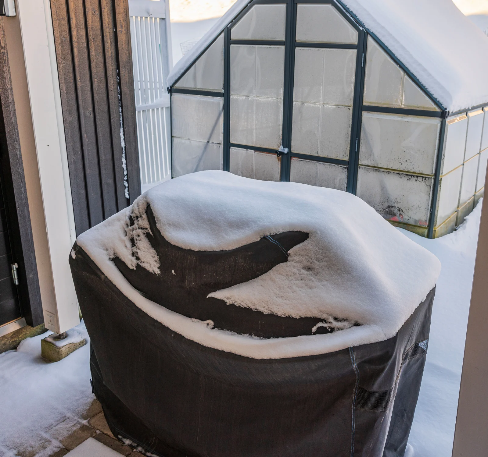 Image d’une housse de barbecue avec de la neige dessus.