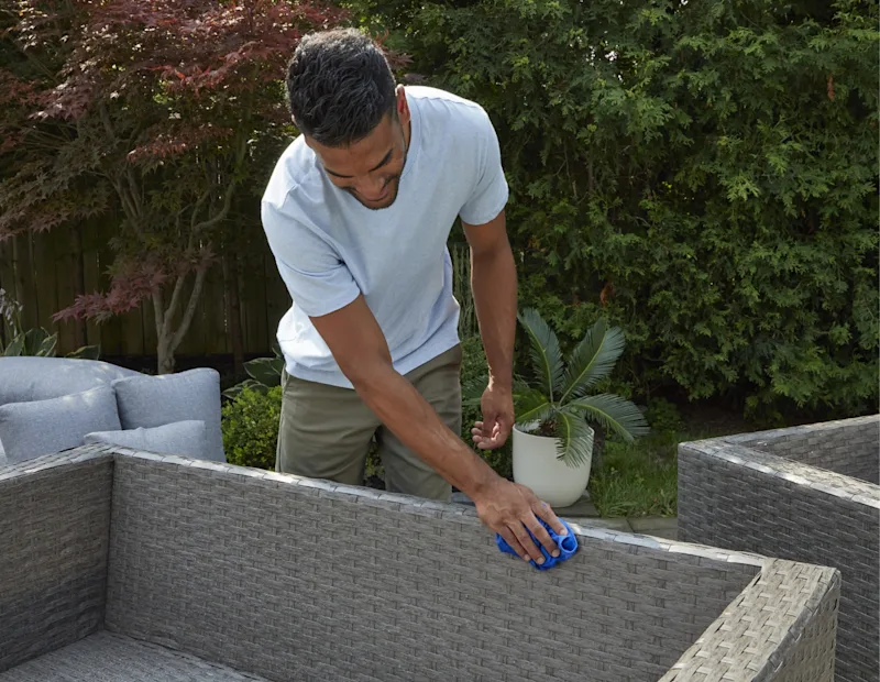 Un homme séchant des mobilier de terrasse