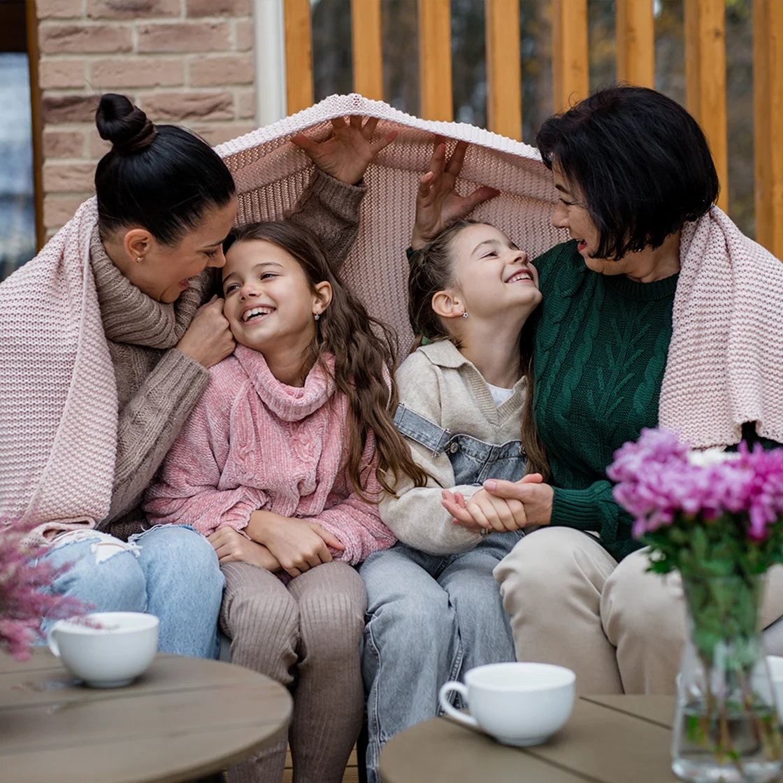 Une famille est assise dehors avec des couvertures.