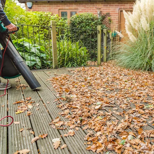 Quelqu'un débarrasse les feuilles sur la terrasse.