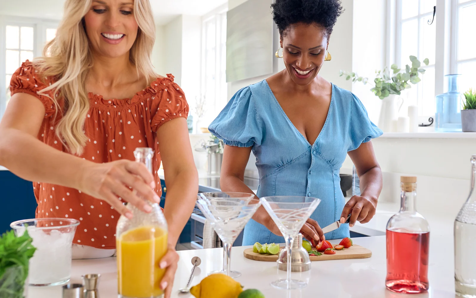 Image de deux femmes préparant des cocktails dans la cuisine.
