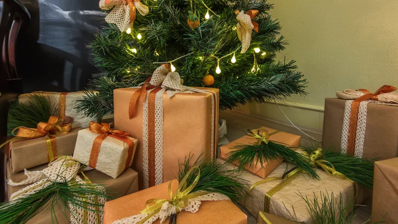 Gifts wrapped in kraft paper under a christmas tree