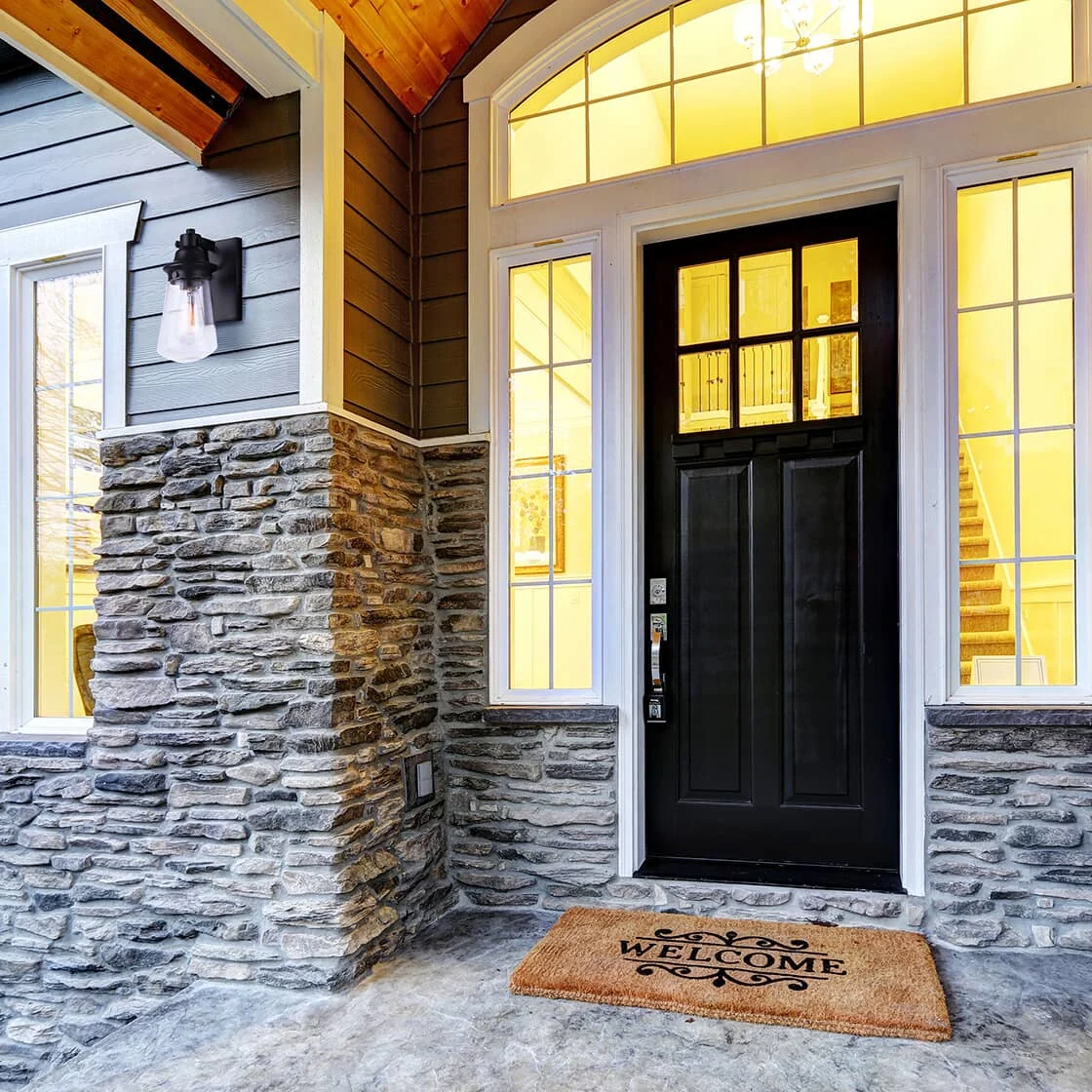 Image of front entrance of a home with interior lights on.
