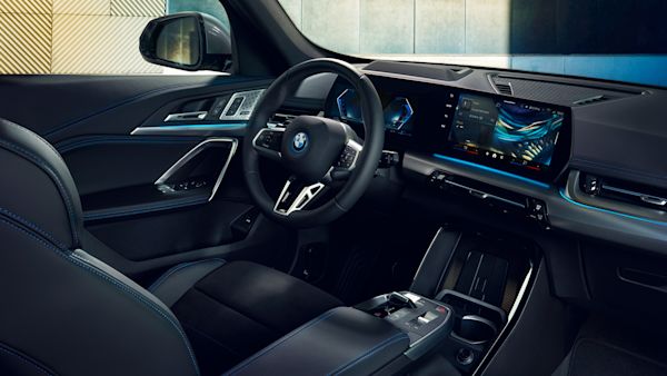 Interior of a modern BMW car showcasing the steering wheel, dashboard with digital displays, and luxurious black leather seats.