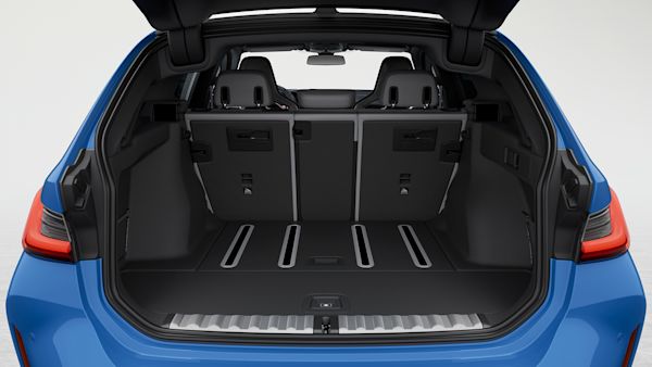 Open trunk of a blue BMW M3 Touring showing spacious cargo area.