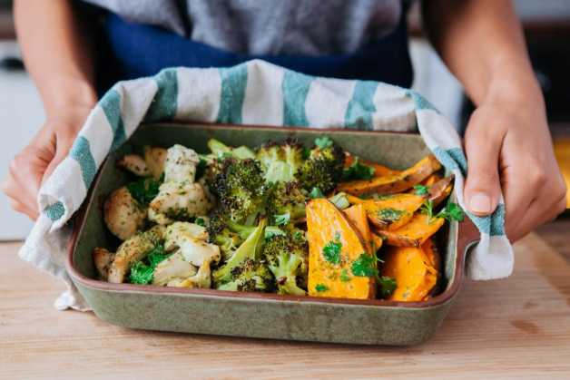 One pan roasted chicken sweet potato broccoli with hands 