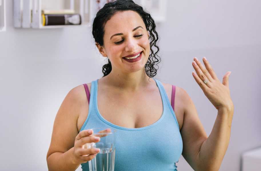 Woman drinking water in blue top (jean)