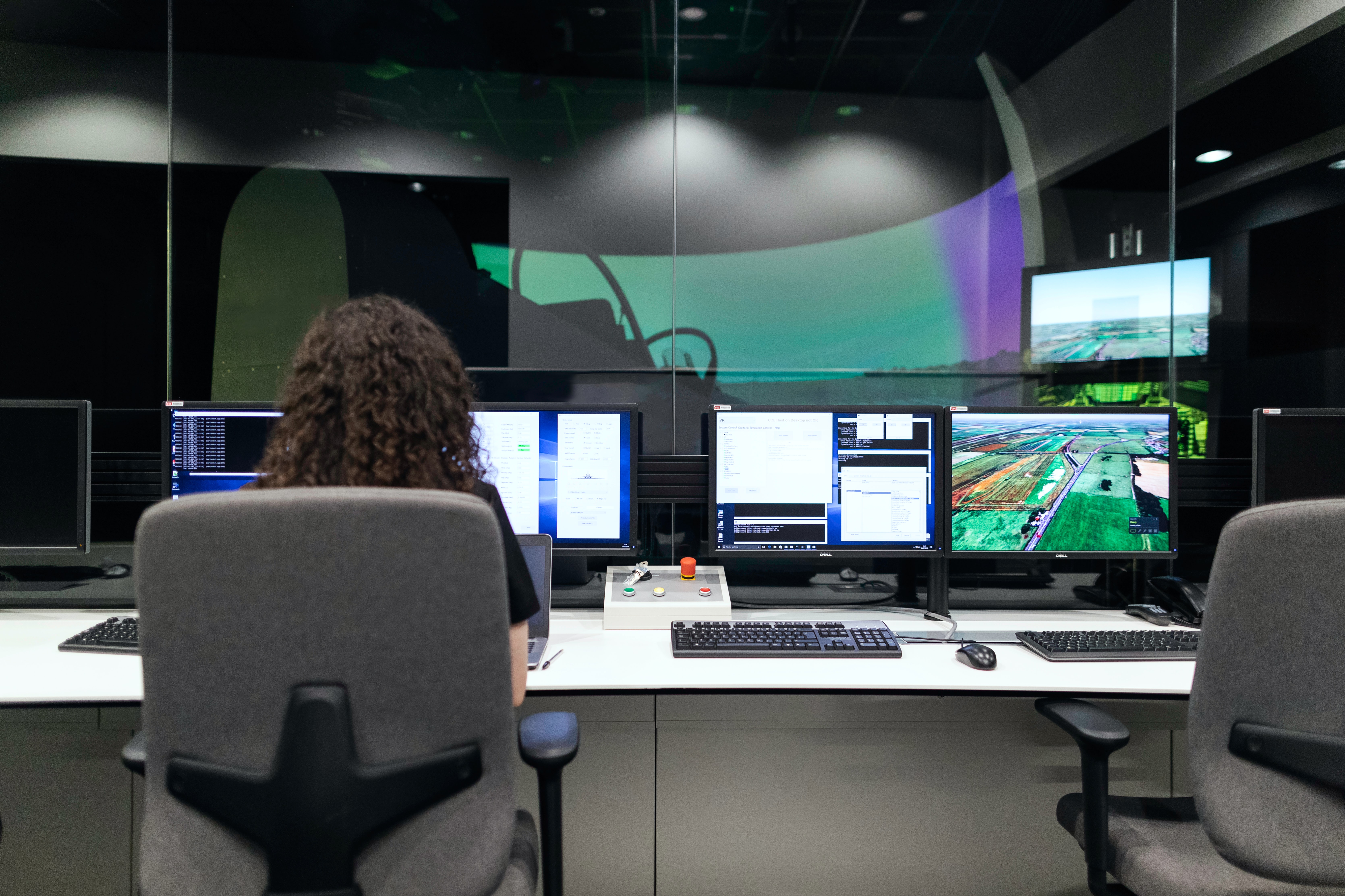 Person sitting at a desk with four monitors