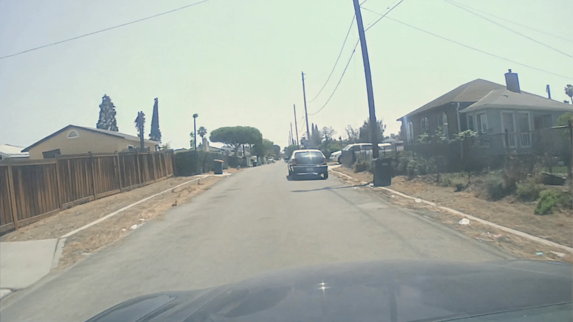 Dash-mounted police cruiser DVR perspective, hood of the patrol car visible at the bottom