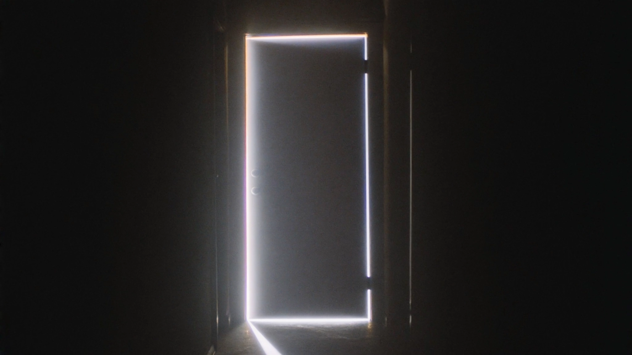A dark interior hallway with a single closed door at the end of the corridor.