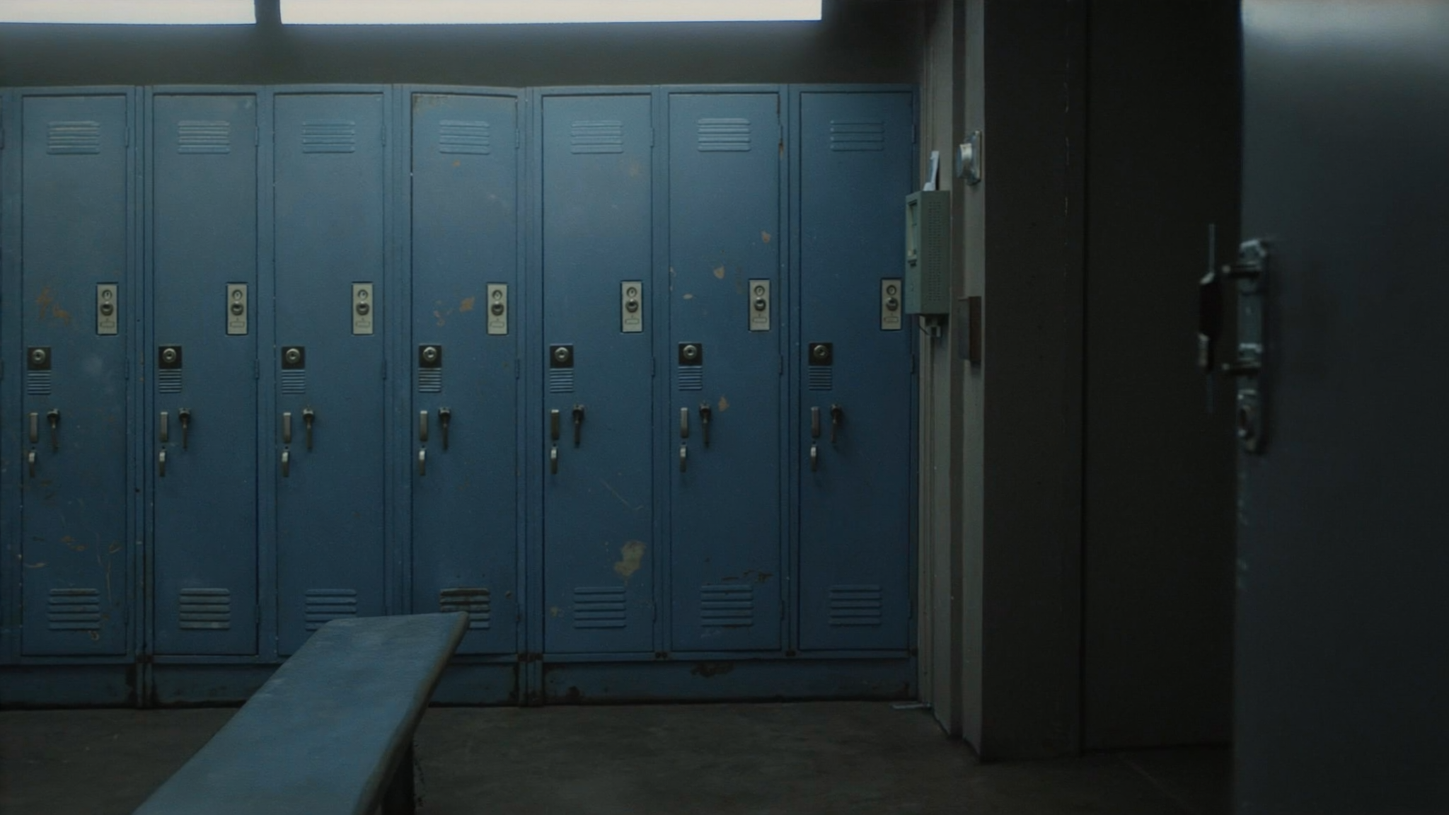 A wide shot of a locker room with blue lockers