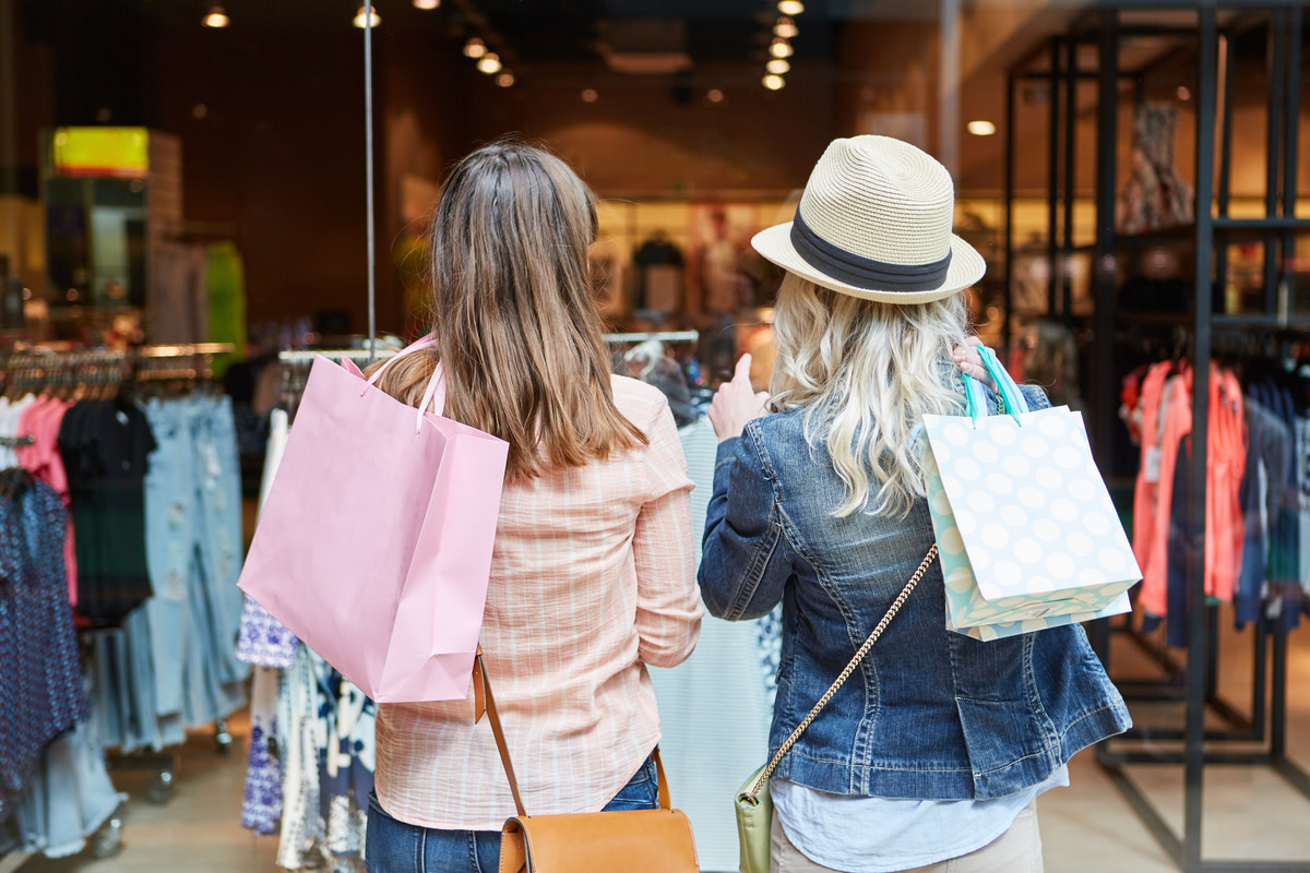 Two women shopping as customers in front of a retail boutique