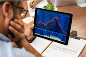 Rear view of stock agent reading bad report and graph