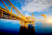 Large Offshore oil rig drilling platform at sunset