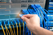 man working in network server room with fiber optic hub