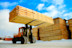 machine is lifting lumber on a wood factory