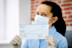 Woman In Face Mask Holding Paycheck