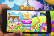 Hand holding phone with Candy Crash Saga logo
