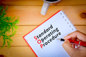 Hand writing Standard Operating Procedure on book